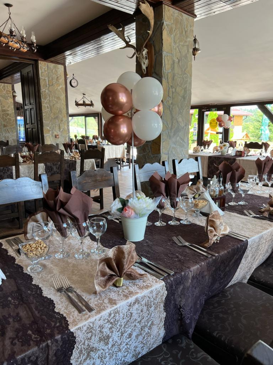 Masă lungă de restaurant cu dantelă, flori și baloane rose-gold