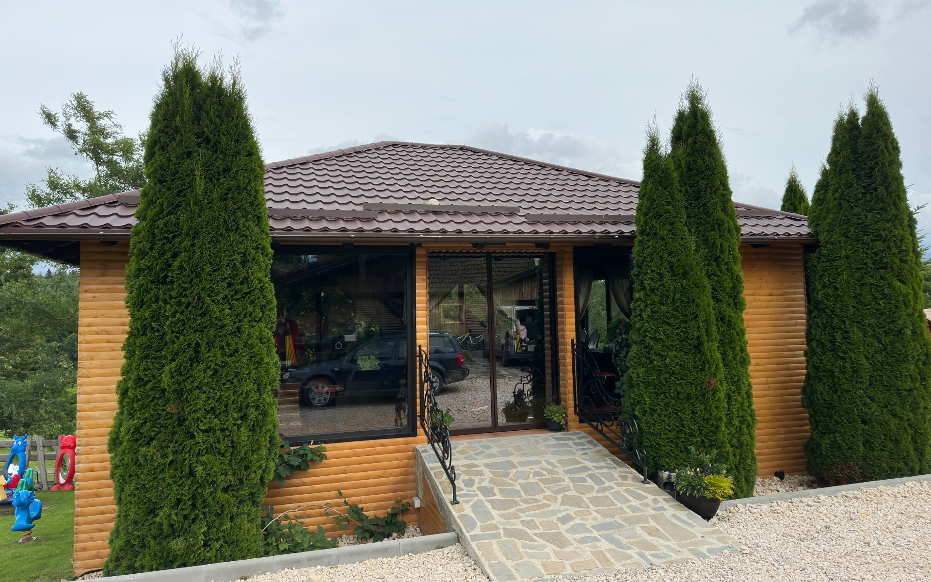 Pavilion din lemn cu ferestre mari și rampă de piatră la Casa Brădet, Întorsura Buzăului