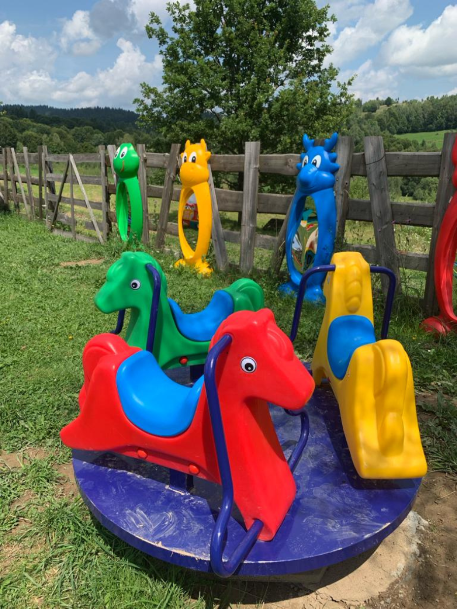 Carusel cu căluți colorați pe iarbă, la Casa Brădet
