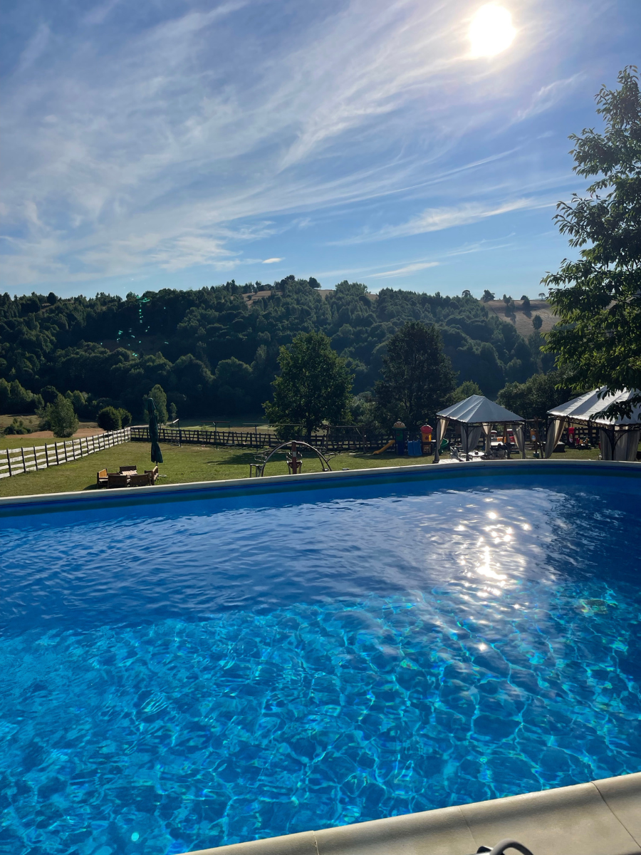Piscina exterioară albastră cu vedere spre dealurile din Întorsura Buzăului