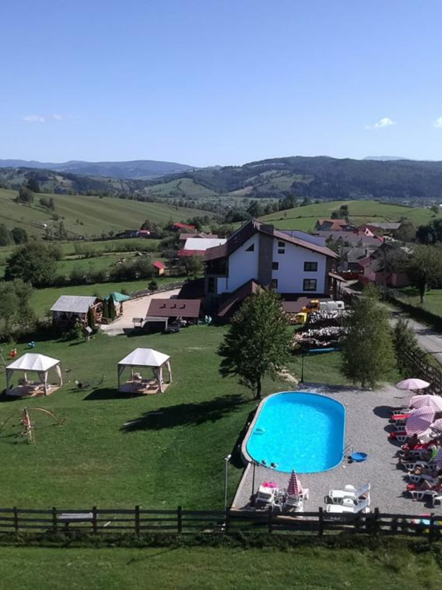 Vedere de ansamblu asupra piscinei, șezlongurilor și clădirii Casa Brădet