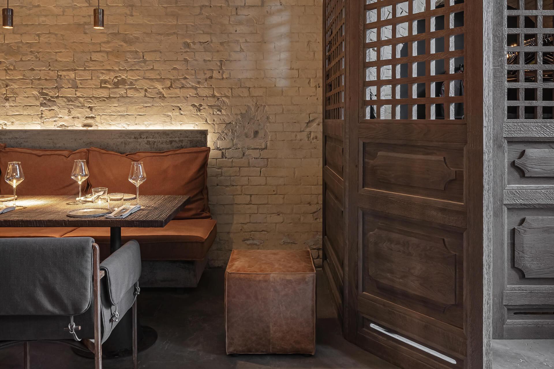 Colț de restaurant cu masă pregătită, perete de cărămidă și separator de lemn