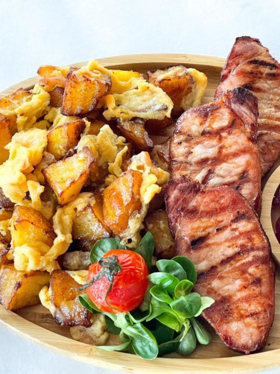 Ceafă la grătar cu cartofi și ouă pe platou de lemn la restaurant